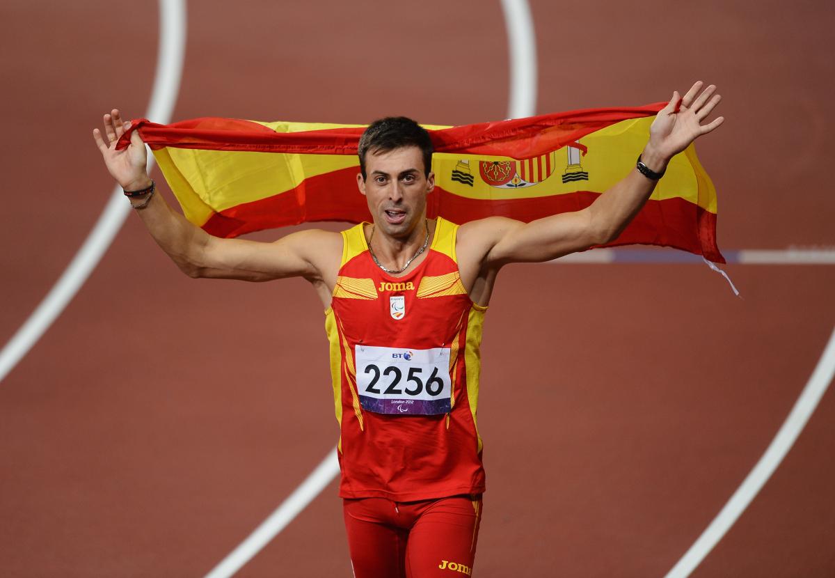 Jose Antonio, salah satu atlet paralympic dari Spanyol berlari dengan bendera negaranya